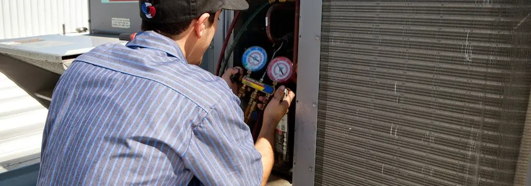 HVAC technician servicing a condenser unit in Pampa