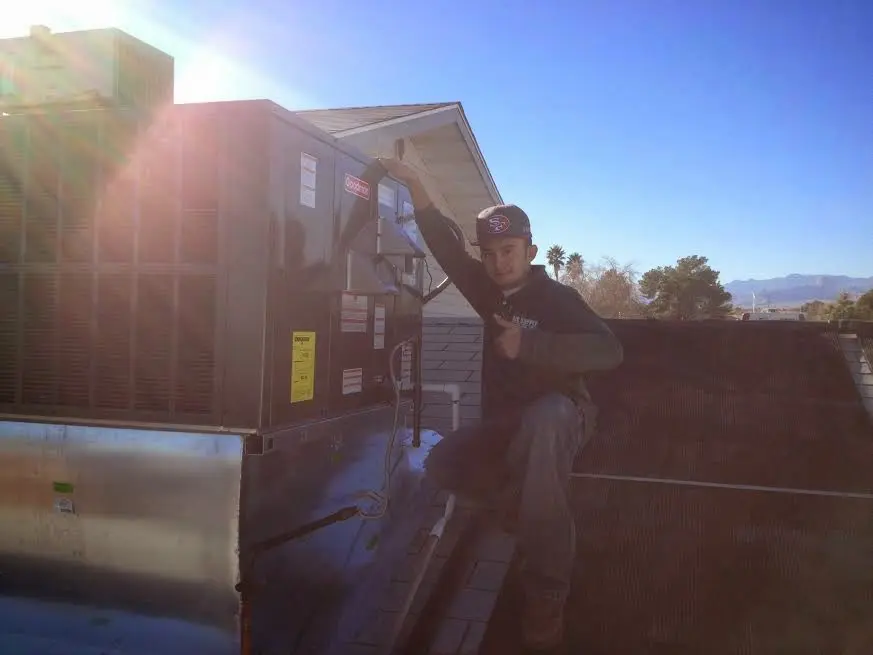 HVAC technician performing HVAC Inspection on a rooftop unit in Pampa